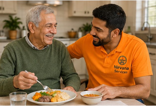A Nirvana Services direct support professional sitting with a man at his kitchen table while he eats a meal.
